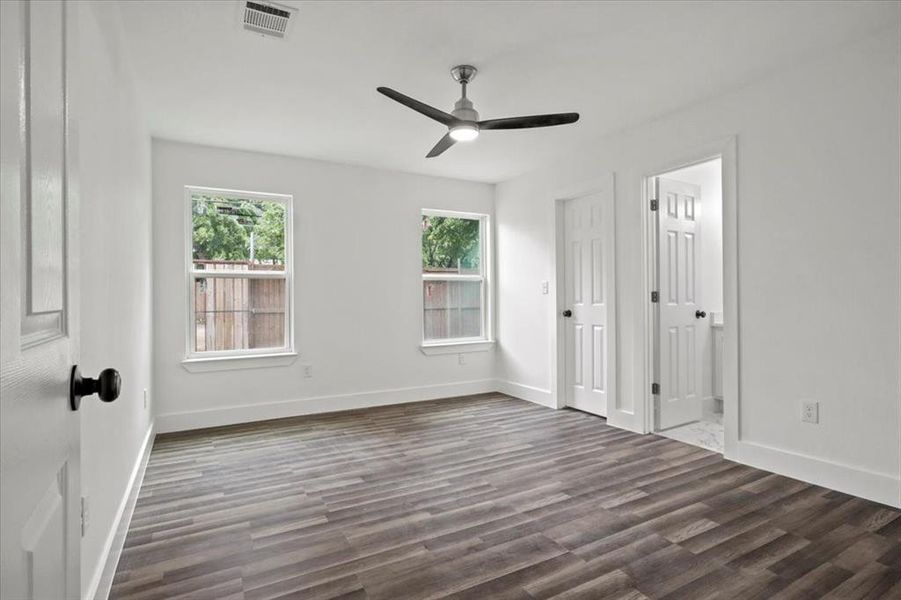 Empty room with dark wood-type flooring and ceiling fan