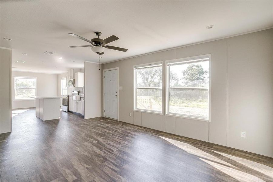 Unfurnished living room with ceiling fan and wood-type flooring