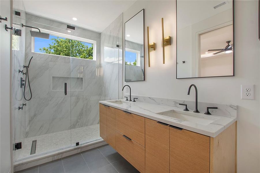 Bathroom with tile floors, walk in shower, ceiling fan, and double sink vanity