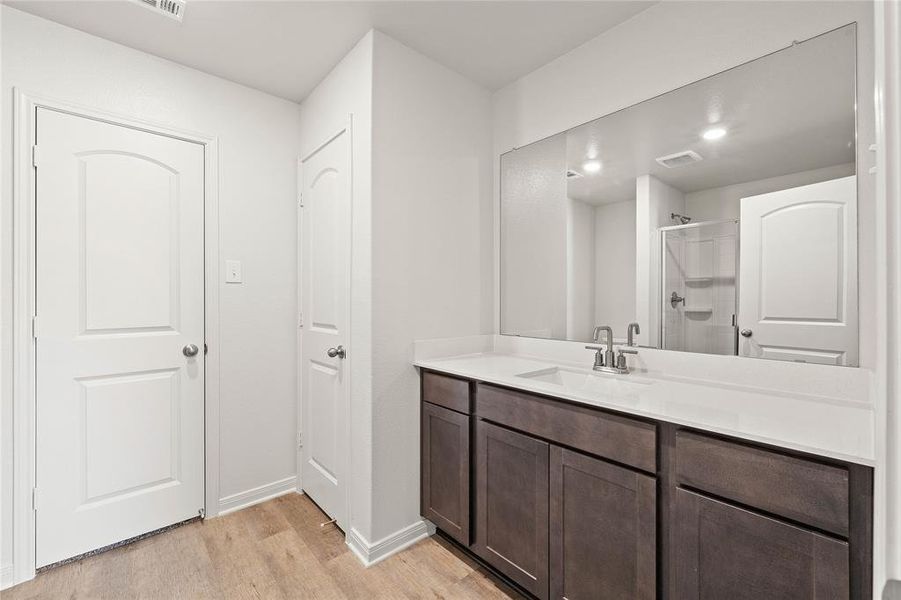 Bathroom featuring vanity, hardwood / wood-style flooring, and an enclosed shower