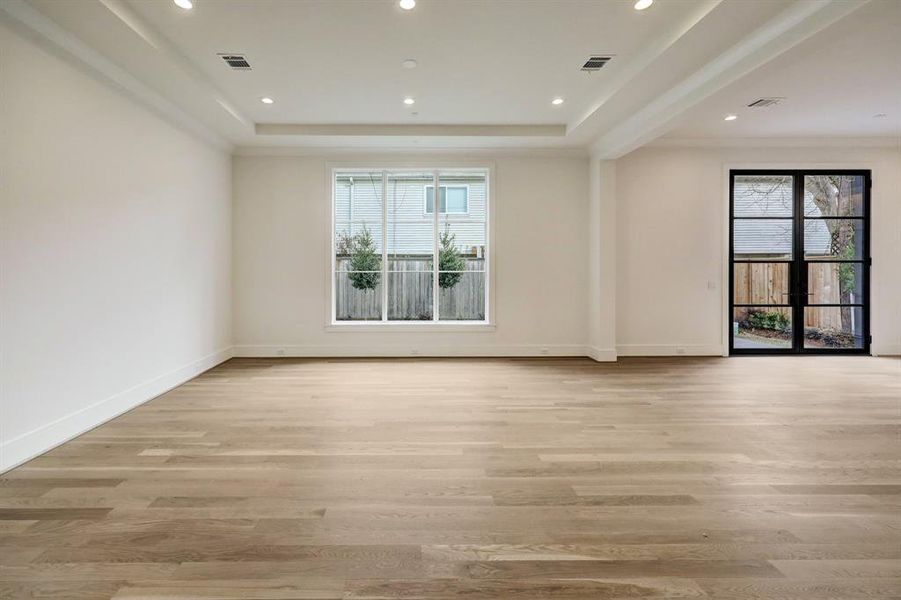 Large dining room is light and bright with large window, recessed ceiling , raised ceiling treatment and  gleaming hardwood floors.