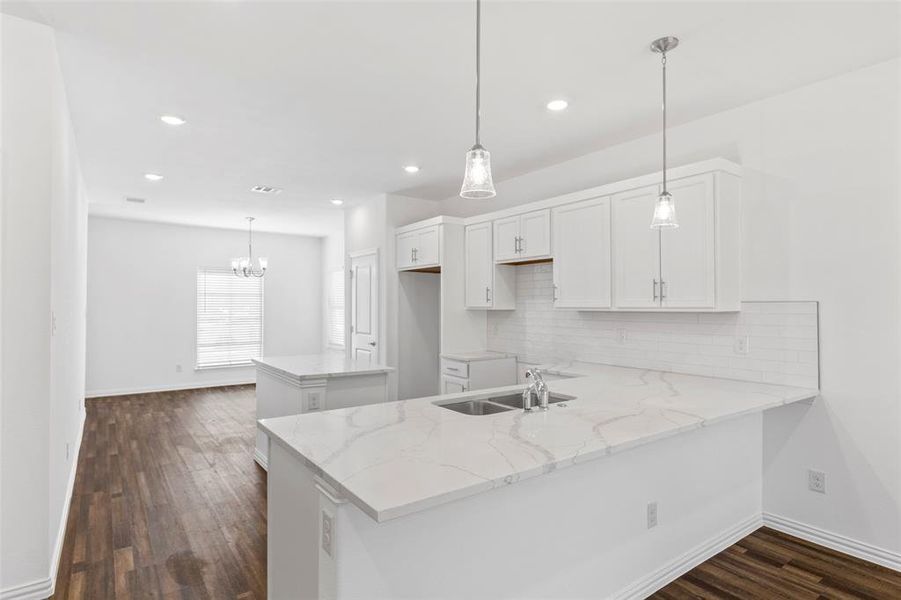 Kitchen featuring sink, kitchen peninsula, white cabinetry, dark hardwood / wood-style floors, and decorative backsplash