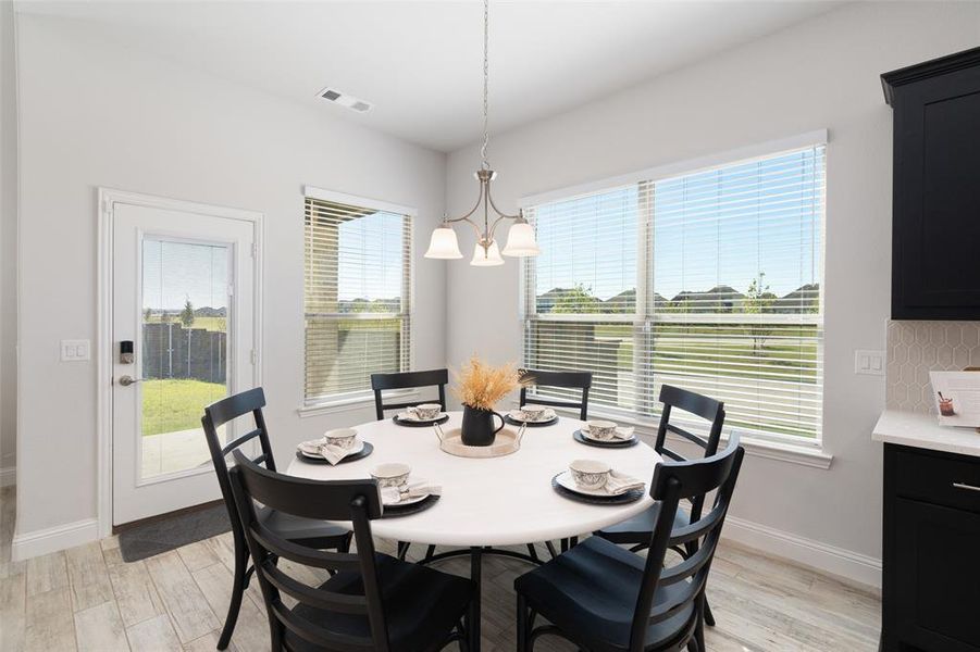 Dining area featuring a notable chandelier, light hardwood / wood-style flooring, and plenty of natural light