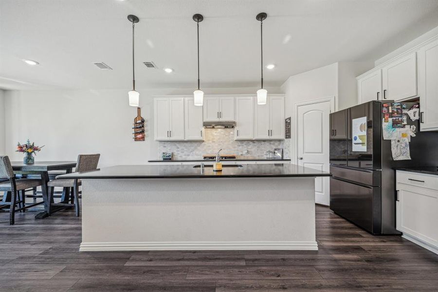 Kitchen with white cabinetry, dark hardwood / wood-style flooring, and hanging light fixtures