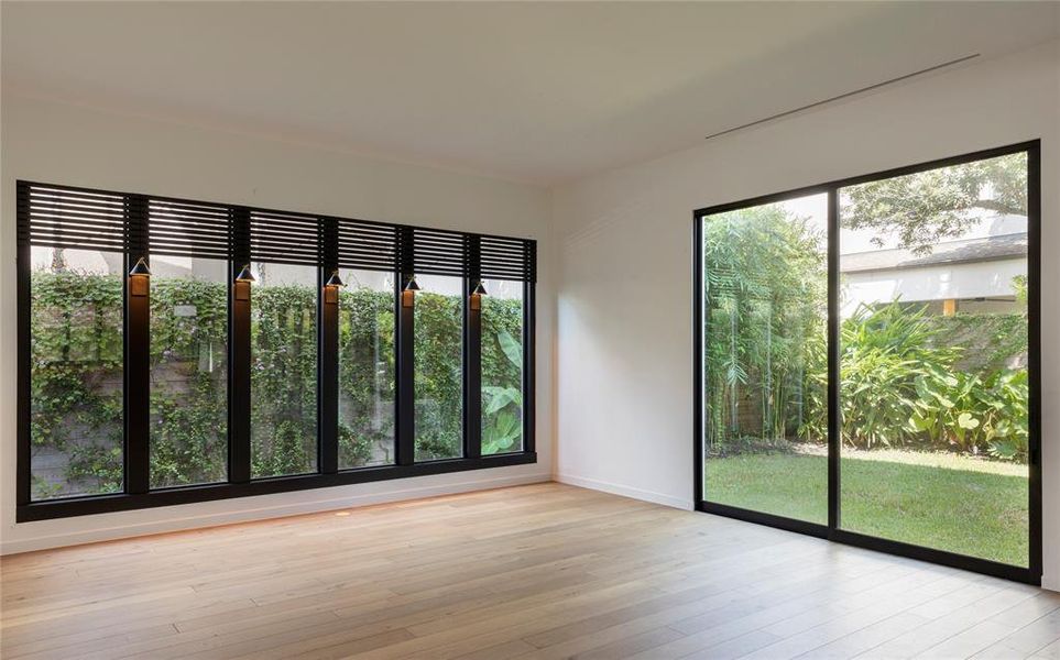 The living room has 2 walls of double-pane windows providing natural light and multiple views of a tropical mature garden.  The Boston Ivy and other  vines were planted in 2019 and provide a green privacy wall along the entire fence line.