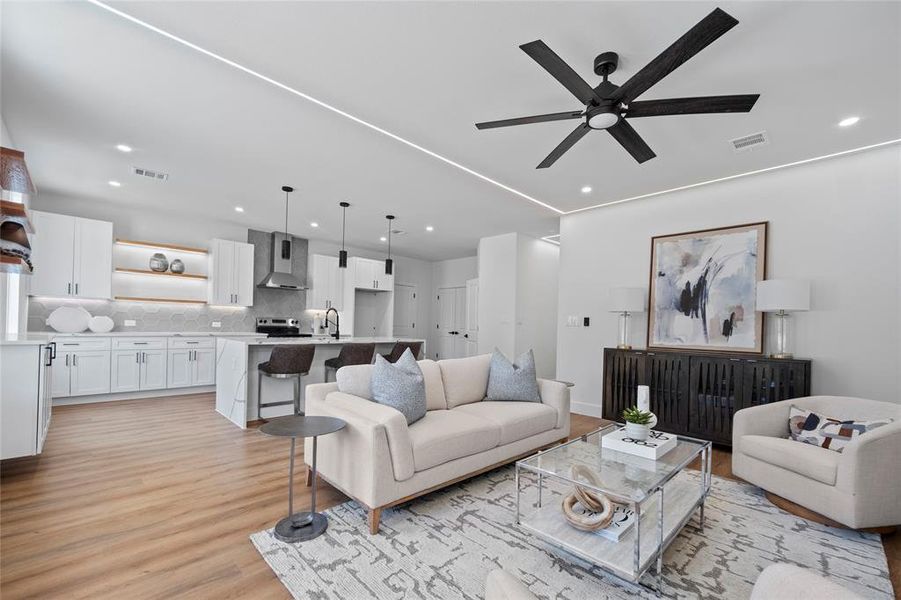 Living room featuring sink, light wood-type flooring, and ceiling fan