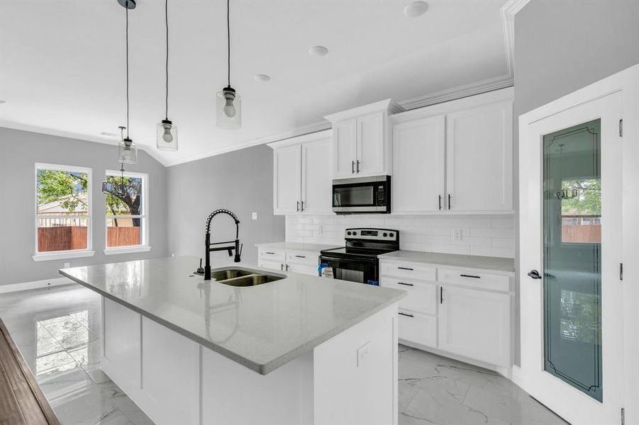 Kitchen with pendant lighting, sink, a center island with sink, range with electric cooktop, and white cabinetry