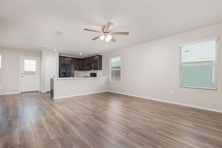 Unfurnished living room featuring light hardwood / wood-style floors, sink, a healthy amount of sunlight, and ceiling fan