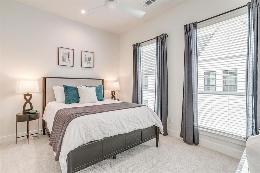 The guest room is bathed in natural light, creating a welcoming and airy atmosphere. With its spacious closet and ensuite bath, your guests will feel right at home, enjoying both comfort and convenience during their stay.