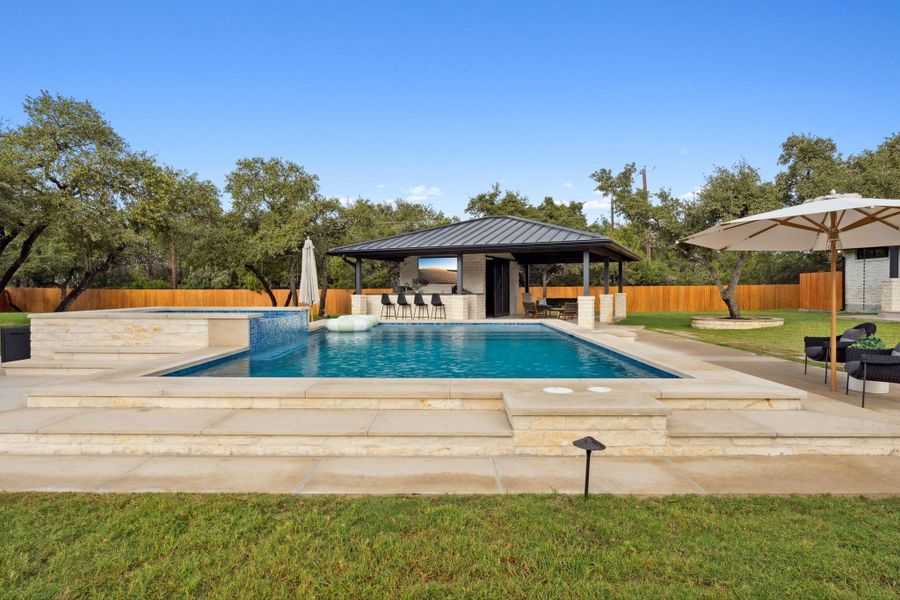 A backyard oasis featuring a pool house, outdoor living area, and fully-equipped outdoor kitchen—an entertainer’s dream come true.