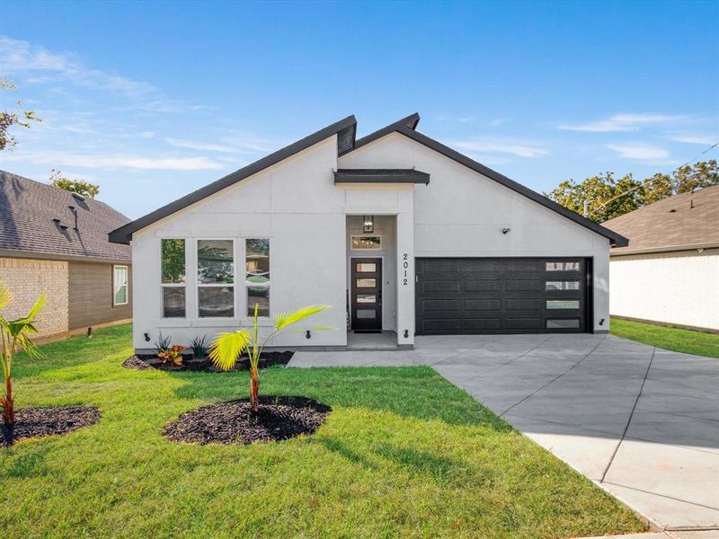 Modern home featuring a front yard and a garage