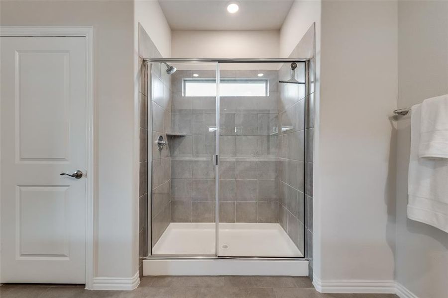 Master Bathroom featuring a shower with shower door and tile flooring