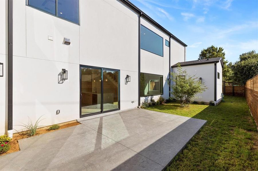 Rear view of house with a patio and a lawn