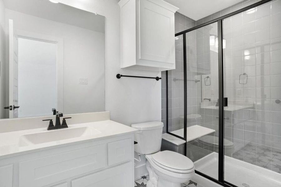 Bathroom featuring toilet, an enclosed shower, and vanity