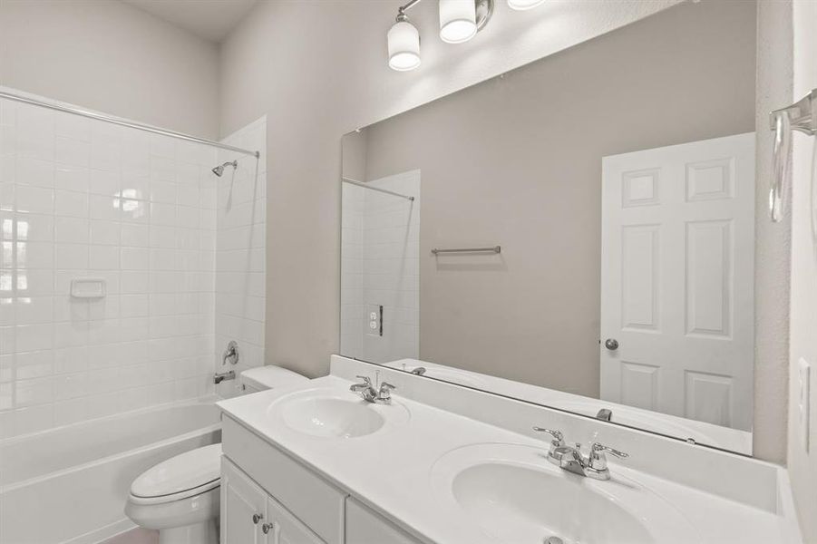 The secondary bath features tile flooring, white cabinetry and light countertops and a shower/tub combo. Perfect for accommodating any visiting family and friends.