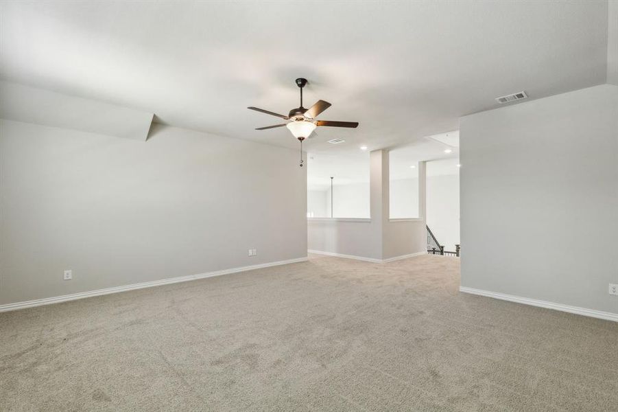 Carpeted spare room featuring ceiling fan