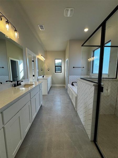 Bathroom featuring vanity, shower with separate bathtub, and tile patterned flooring