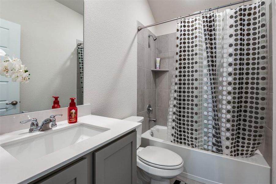 Full bathroom featuring vanity, shower / tub combo with curtain, and toilet