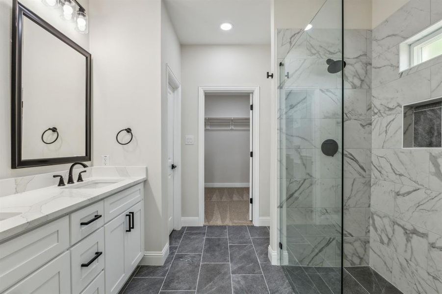 Bathroom with vanity, tile patterned floors, and tiled shower