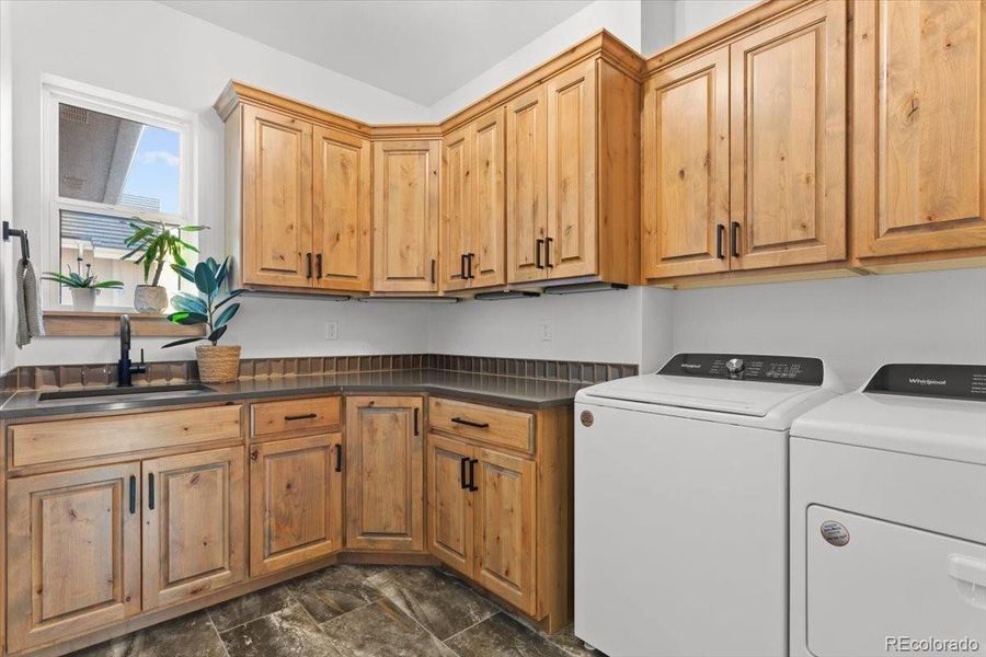 Laundry Room Includes Lots of Cabinets, Quartz Countertops, and a Granite Composite Sink