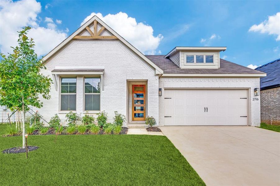 View of front of house with a garage and a front yard