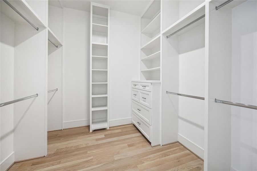 The primary suite boasts excellent storage solutions, featuring spacious dual walk-in closets with built-in cabinetry in each.