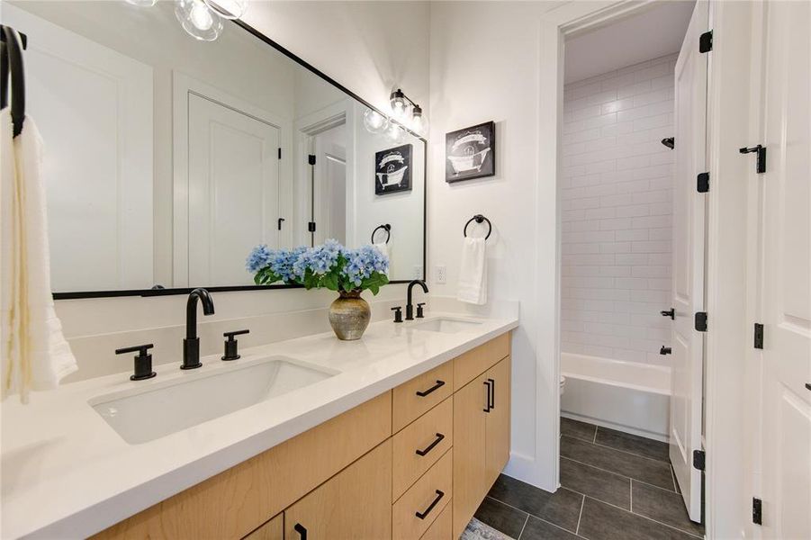 *Photos from recently completed home with same floorplan. Tile and hardware selection will be different. This build will have two guest baths with single vanities versus one guest bath with a double (pictured here).