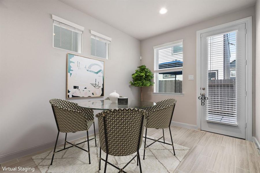 You and your guests will certainly dine in style in this amazing dining room! Featuring a large window and door with blinds, neutral paint, high ceilings, and wood look tile flooring. Perfect space to entertain family and friends.