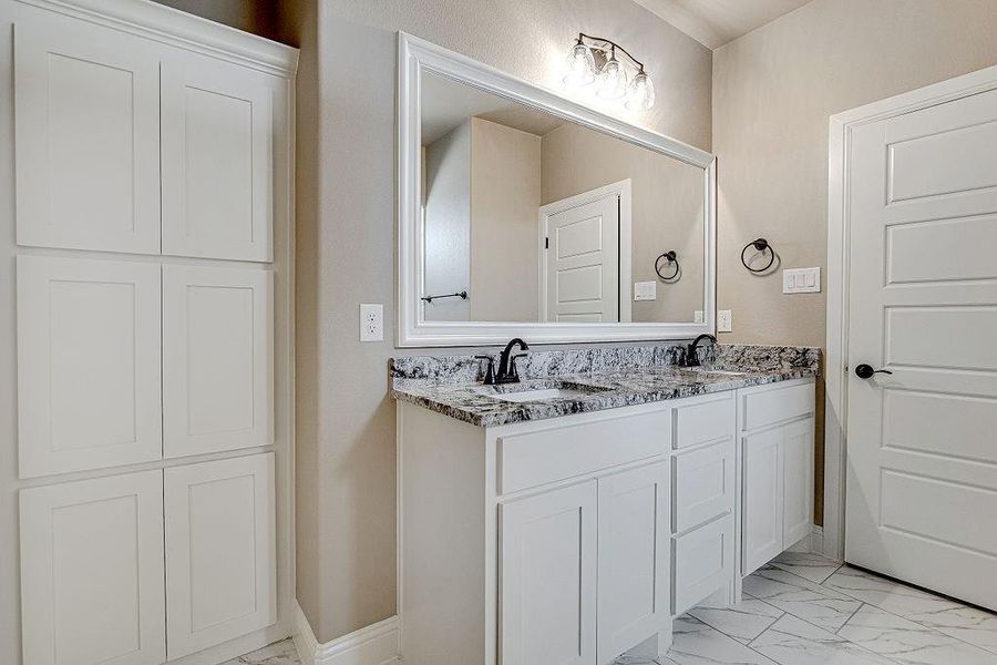 Bathroom with tile patterned flooring and dual vanity