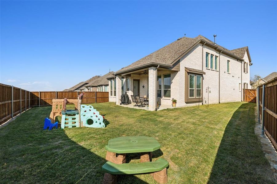 Back of house featuring a large yard and a patio area with gas stub for a grill.