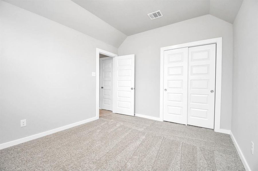 Secondary bedroom features plush carpeting, large windows that let in plenty of natural light, bright paint, and spacious closets. Sample photo of completed home with similar floor plan. Actual colors and selections may vary.