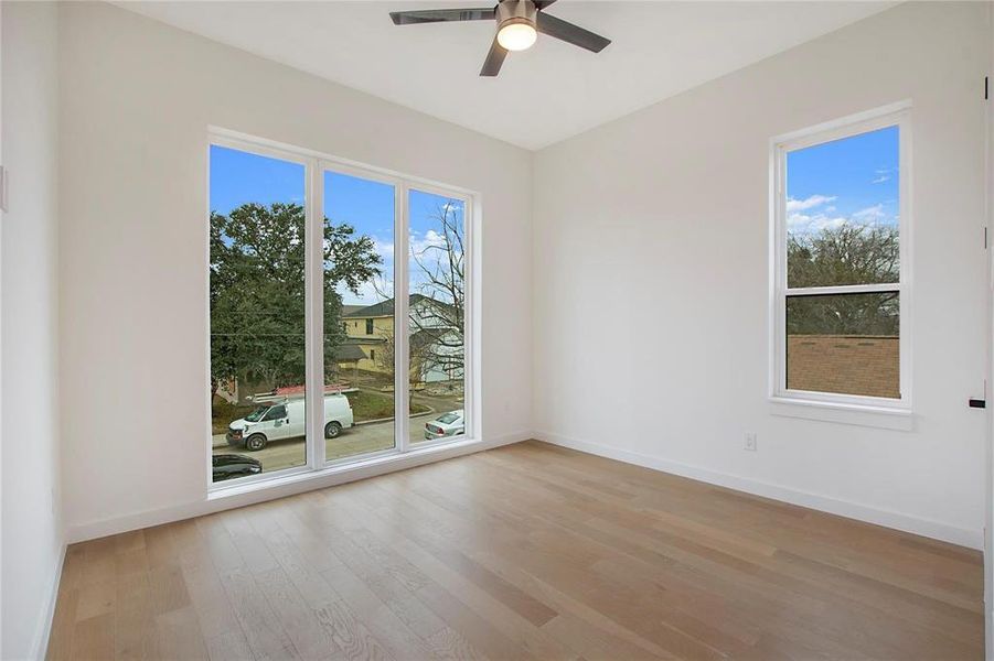 Spare room with ceiling fan, light hardwood / wood-style flooring, and plenty of natural light