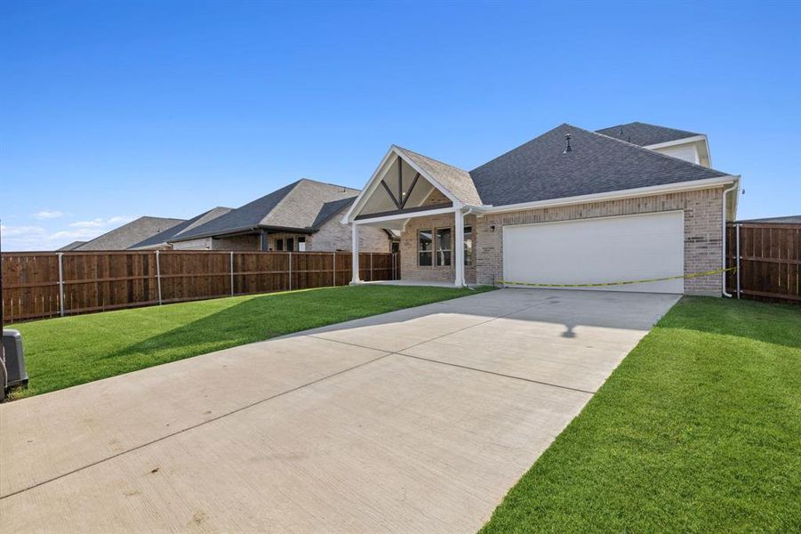 View of front of property featuring a garage and a front yard