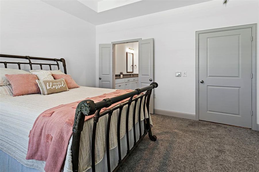 Carpeted bedroom featuring ensuite bathroom