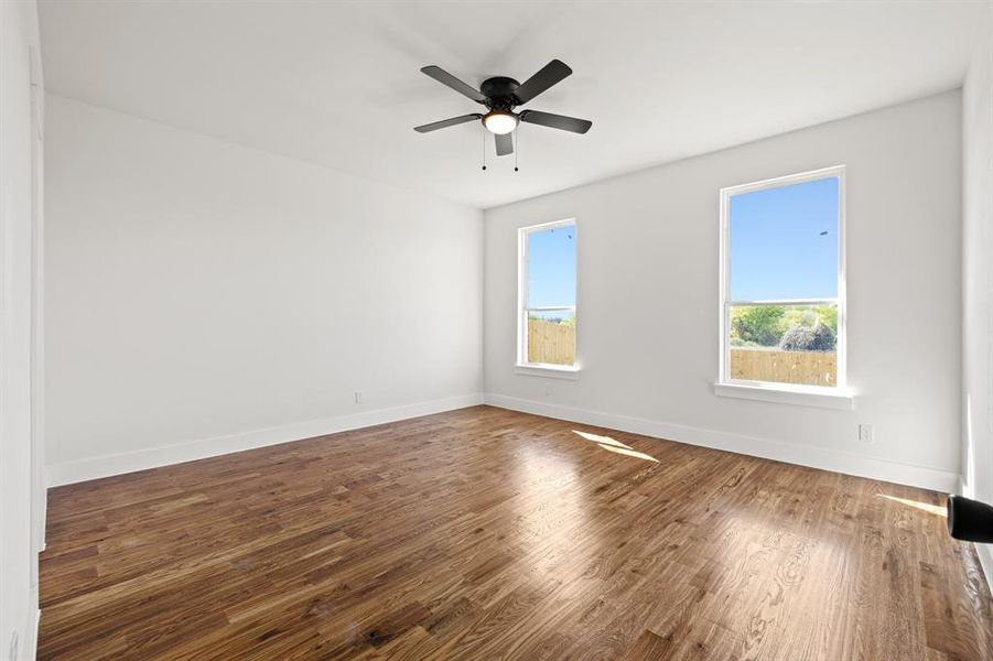 Unfurnished room with a healthy amount of sunlight, ceiling fan, and hardwood / wood-style floors