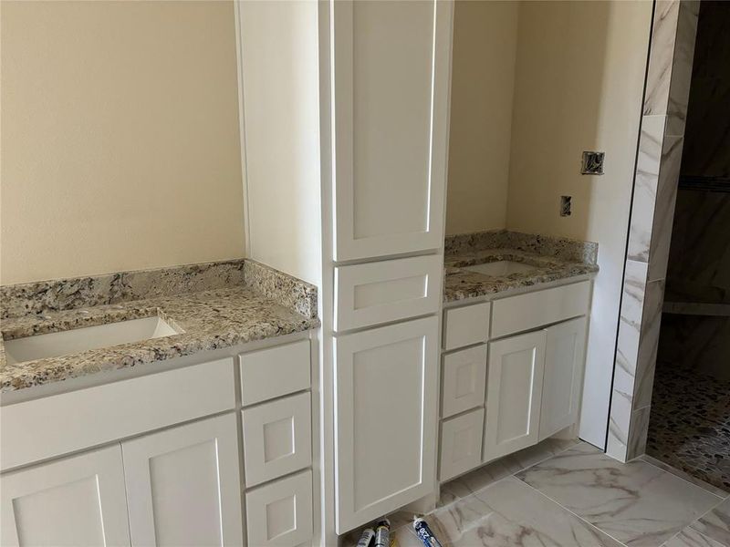 Bathroom with solid wood white cabinets and granite countertops.