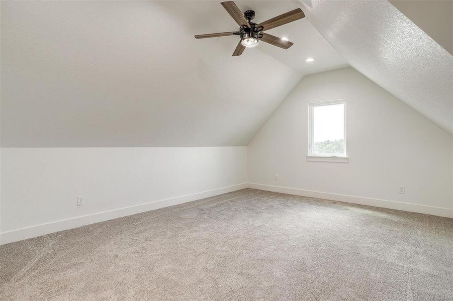 Bonus room featuring vaulted ceiling, a textured ceiling, ceiling fan, and carpet floors