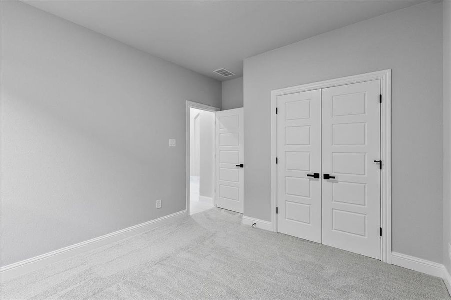 Unfurnished bedroom with a closet and light carpet