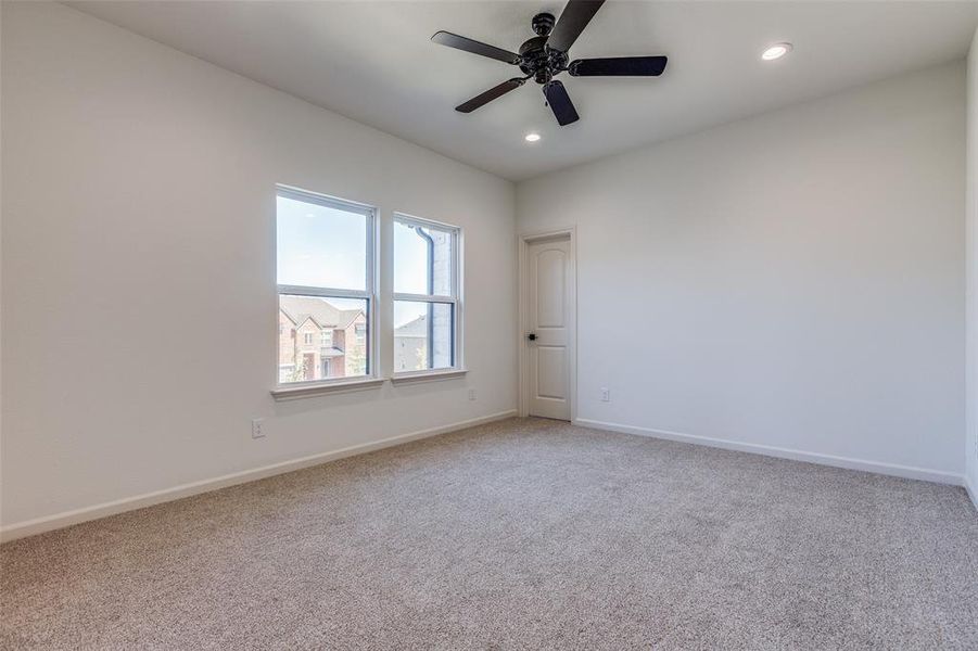 Carpeted spare room featuring ceiling fan