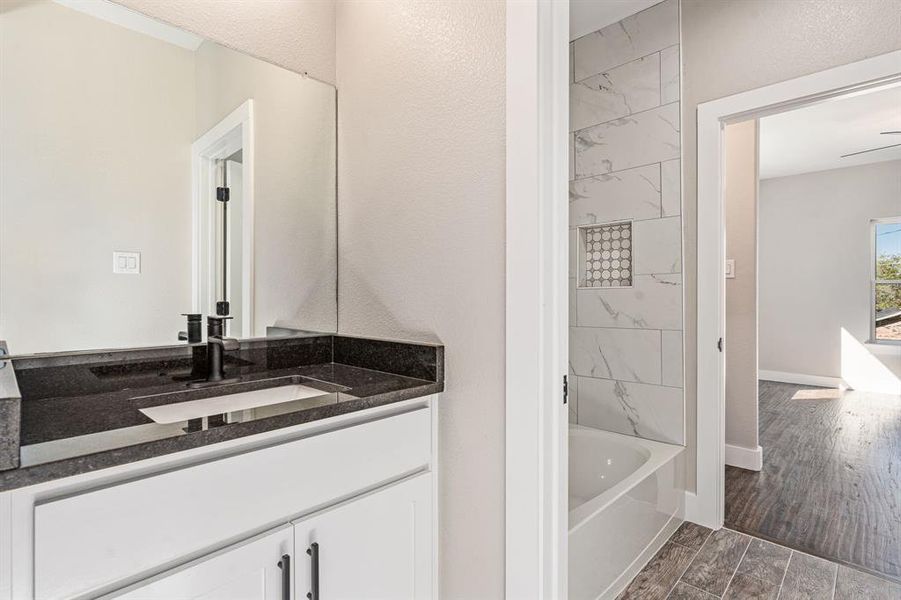 Bathroom with vanity, a bathing tub, and hardwood / wood-style flooring