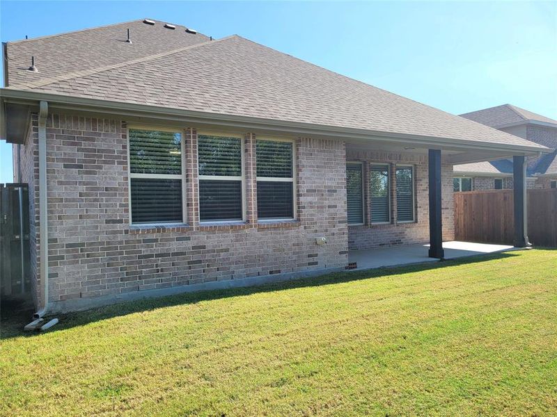 Rear view of property with a lawn and a patio area