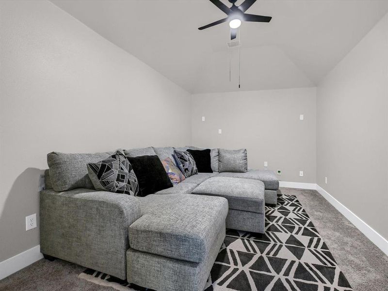 Living room with lofted ceiling, carpet, and ceiling fan