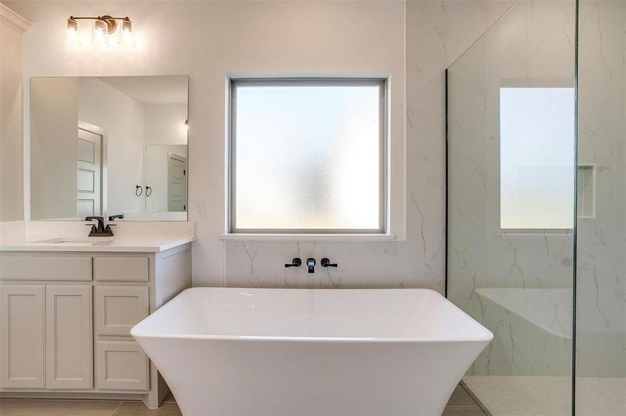 Bathroom featuring vanity, shower with separate bathtub, and tile patterned floors