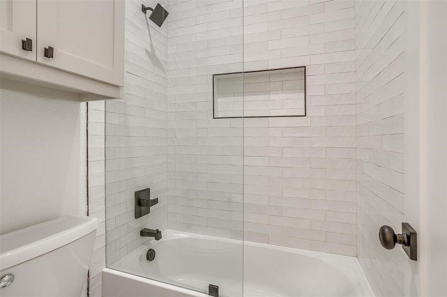 Bathroom featuring toilet and tiled shower / bath