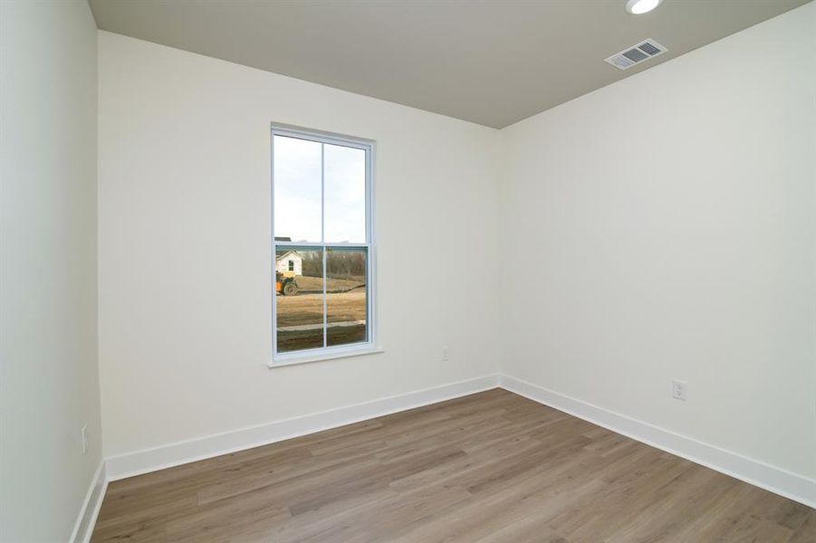 Empty room with hardwood / wood-style floors