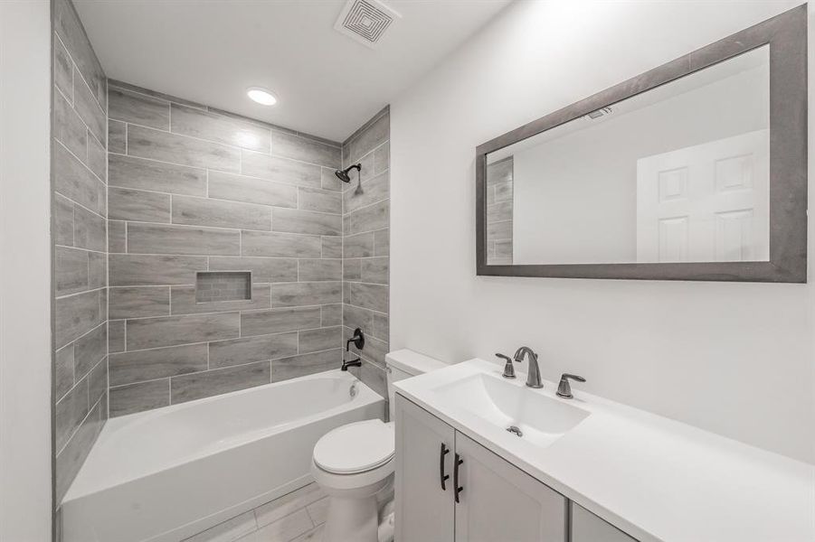 Full bathroom with vanity, toilet, and tiled shower / bath