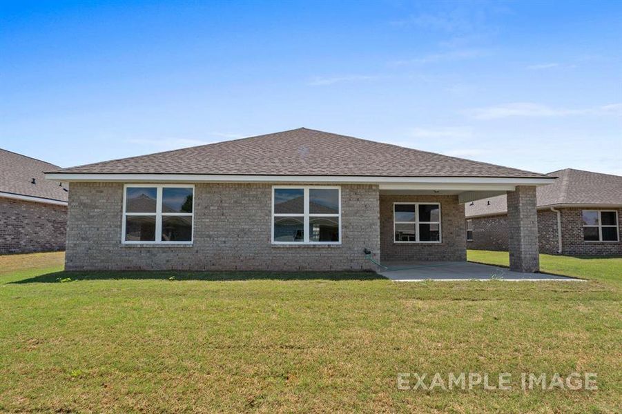 Rear view of house featuring a yard and a patio