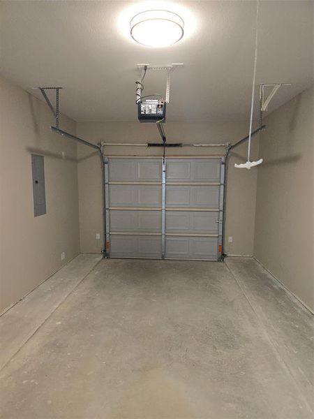 Garage with electric panel and a garage door opener