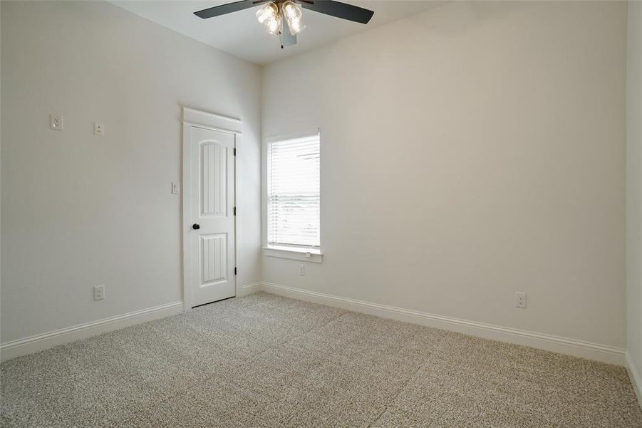 Carpeted spare room featuring ceiling fan