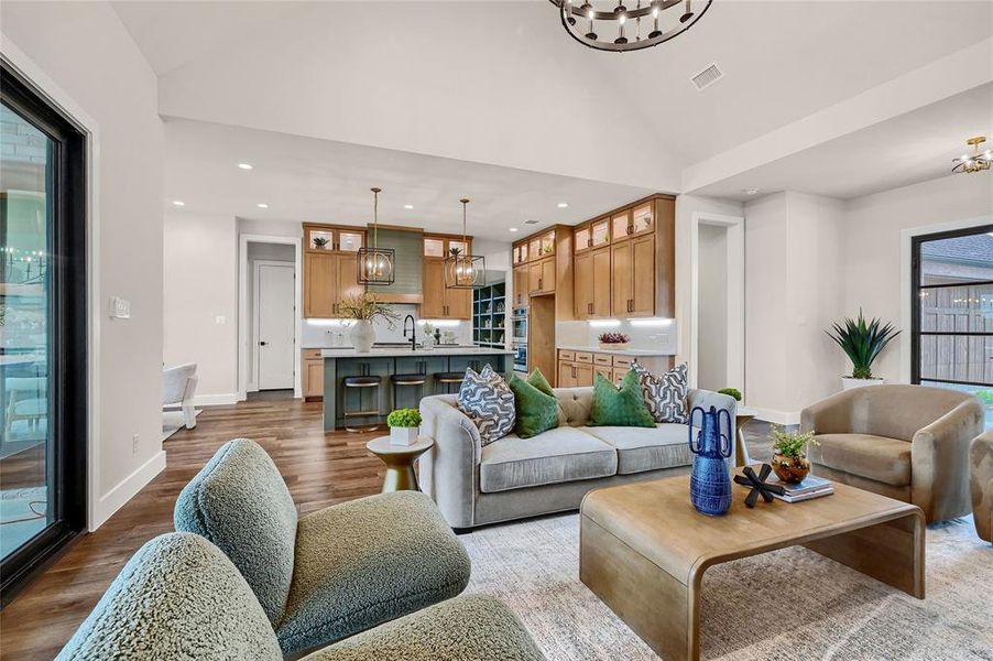 Living room featuring lofted ceiling, hardwood / wood-style floors, and sink